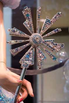 a close up of a woman's hand holding an elaborately designed hair comb