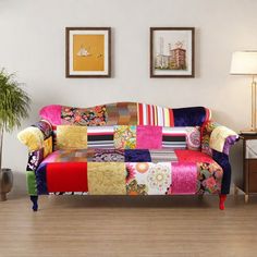 a living room with a couch covered in colorful patchwork fabric and two lamps on the side tables