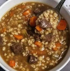 a white bowl filled with meat and barley soup