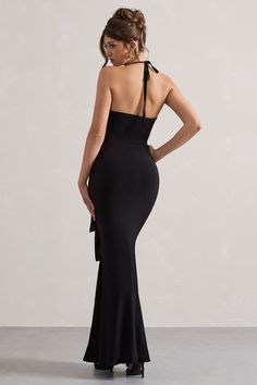 a woman in a black dress with her back to the camera