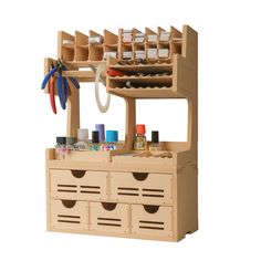 a wooden crafting stand with drawers and tools on the top shelf, holding supplies