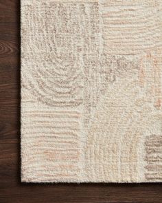 an area rug on top of a wooden floor with wood grains in the background