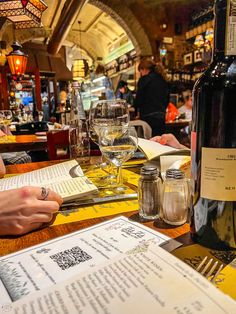 a bottle of wine sitting on top of a table next to a glass of wine