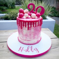 a birthday cake with pink icing and decorations