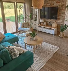 a living room filled with furniture and a flat screen tv mounted on a wall above a fireplace