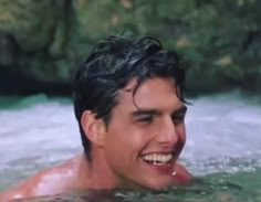 a man swimming in the water with his mouth open and tongue hanging out, smiling