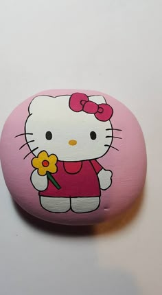 a hello kitty rock with a flower on it