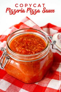 a jar filled with pizza sauce sitting on top of a checkered table cloth