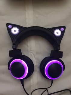 a pair of headphones with cat ears and glowing eyes on top of a white sheet