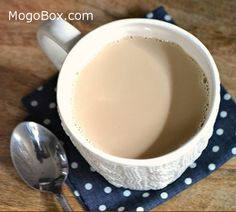 there is a cup of coffee on the table with spoons next to it and a napkin