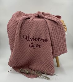 a pink blanket sitting on top of a wooden chair