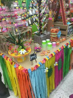 an assortment of colorful items on display at a fair or party with paper streamers in the shape of flowers and leaves