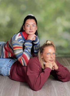 two women are laying on the floor with their heads turned to look like they're looking at something