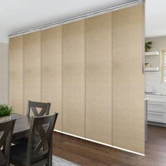 a dining room with a table and chairs next to a sliding glass door that has blinds on it