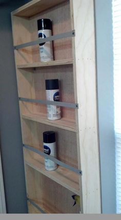 the shelves are made out of plywood and have paint cans on them for storage