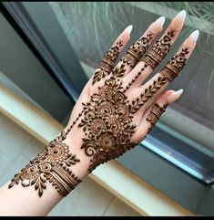 a woman's hand with henna tattoos on it