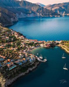 an aerial view of a bay with boats in the water and mountains in the background