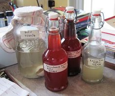 three bottles of liquid sitting on top of a table next to papers and other items