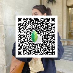 a woman holding up a piece of paper with a qr code on it