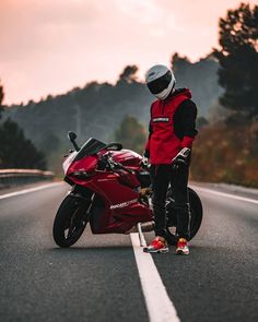 a person standing next to a red motorcycle