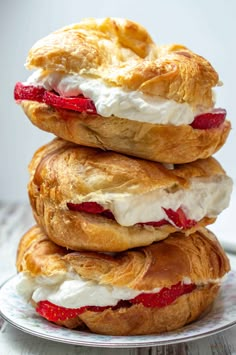 three pastries stacked on top of each other with cream cheese and strawberries in between