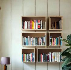 the bookshelf is filled with many different types of books and has a potted plant next to it