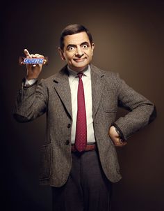 a man in a suit and tie holding a candy bar