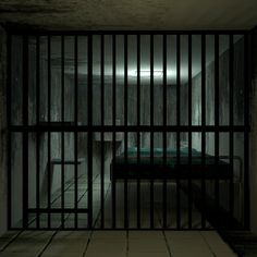 a jail cell with a bed in it and bars on the doors that lead to another room