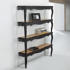 a shelf with books and pictures on it in the corner next to a wall mounted clock