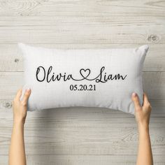 a person holding up a pillow that says,'personalized with the names and date