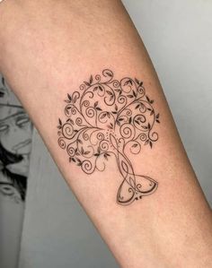 a woman's arm with a tree tattoo on it