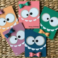 four birthday cards with cartoon eyes and bows are on a wicker basket in front of a woven basket