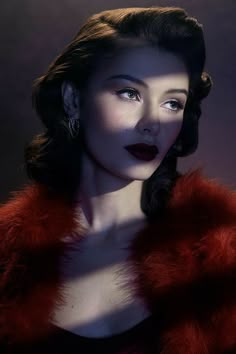 a woman in a red fur coat with dark lipstick on her face and one eye open