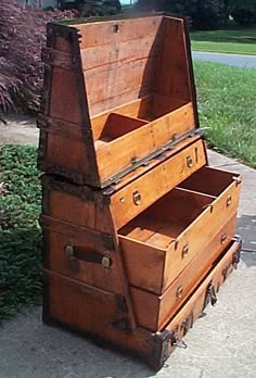 an old trunk sitting on the side of a road next to a bush and sidewalk