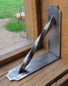 a piece of metal sitting on top of a window sill