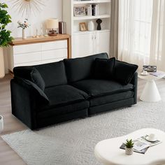 a black couch sitting on top of a white rug