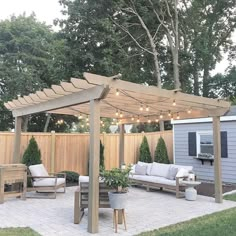 an outdoor living area with patio furniture and string lights on the pergolated roof