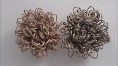 two crocheted flowers sitting next to each other