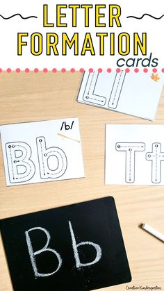 letter formation cards with the words b and h written on them, next to a blackboard