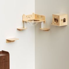 three wooden shelves on the wall and one with a birdhouse in it's mouth