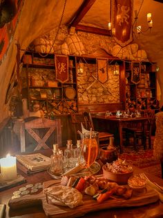 a wooden table topped with lots of food next to a candle and some bottles on top of it