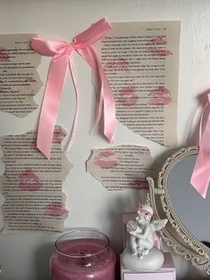 there is a pink candle and some paper on the wall next to a vanity mirror