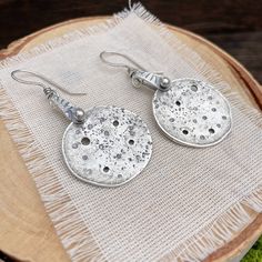 Experience the beauty of handcrafted design with these unique oxidized sterling silver disc earrings. Each pair is carefully crafted with intricate texture, holes, and character, making them one-of-a-kind.  The oxidization process gives the silver a stunning vintage look, perfect for making a statement.  Whether you're dressing up for a night out or just adding some extra style to your everyday look, these earrings are a must-have.   Add a touch of artisanal charm to your jewelry collection toda Medallion Earrings, Earwigs, Character Making, Roanoke Va, Artisan Earrings, Disc Earrings, Large Earrings, Oxidized Sterling Silver, Sheet Metal