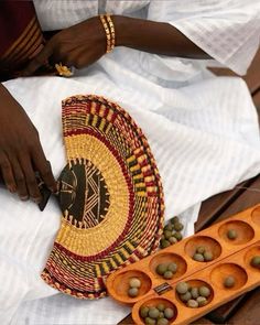 a woman is holding a tray with green olives in it next to some other items