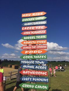 people are standing in front of a sign pointing to different places on the same pole