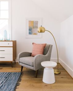 a living room with a chair, lamp and rug