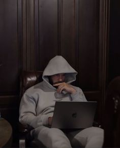 a person sitting in a chair with a laptop