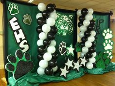 some black and white balloons are in the shape of letters with paw prints on them