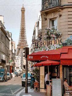 the eiffel tower is in the background of this street scene