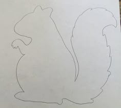 a drawing of a squirrel sitting on top of a table next to a piece of paper